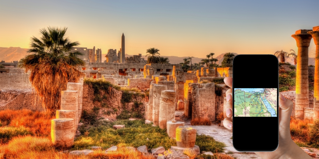 Traveler using eSIM mobile data in Egypt to access Google Maps at the Luxor Temple ruins during sunset.