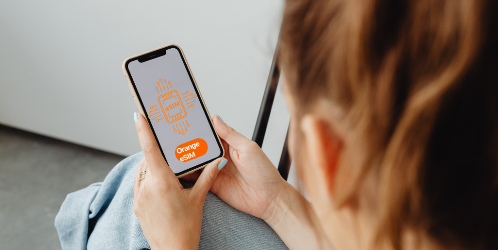 Traveler holding a smartphone while activating an eSIM, representing Orange Egypt eSIM setup process